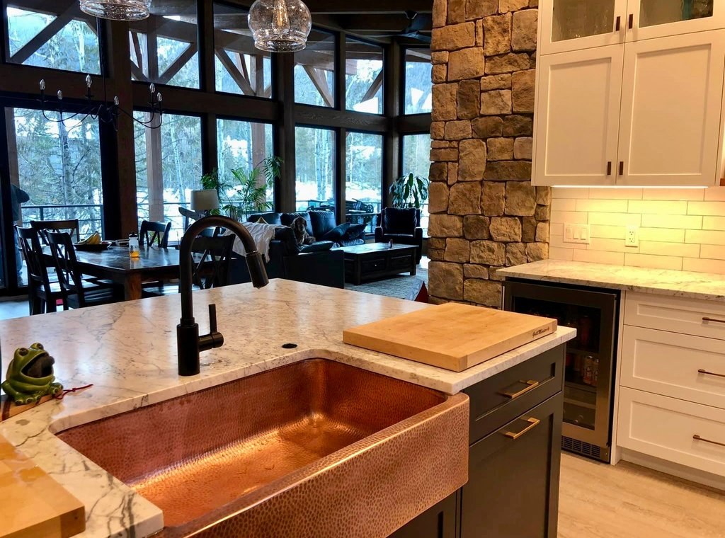 Hand-hammered copper farmhouse sink with marble countertop